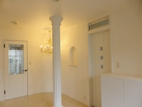 白で統一された玄関ホール。既存の柱に、神殿風の造作材を取付けゴージャスに。